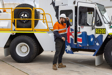 Young adult worker standing beside crane machine