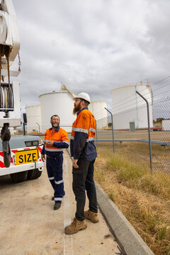 Male workers inspecting the crane truck on industrial site