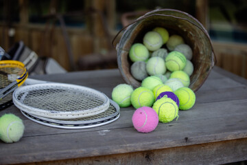 Rustic old tennis racquets and balls on outdoor table