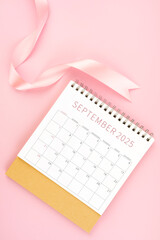 September 2025 desk calendar with pink ribbon.