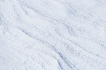 Natural diagonal wavy lines on surface of fresh white snow