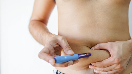 The diabetic patient hand using the insulin pen injection medical equipment to check and control the diabetics at home.
