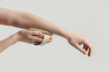 Dry body brush, Woman dry brushing body to reduce cellulite, detoxify the lymphatic system, and...