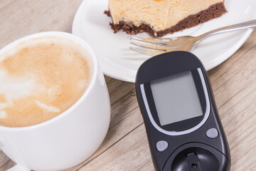 Glucose meter, piece of sweet cheesecake and cup of coffee with milk. Checking sugar level during diabetes