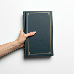 Fototapeta premium woman's hand holding a blue book with gold accents against a white background