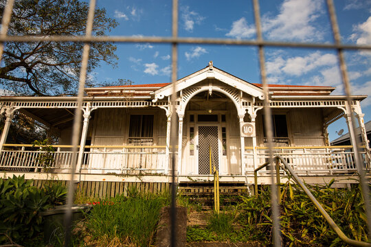 old rundown queenslander behind a safety fence on a sunny day