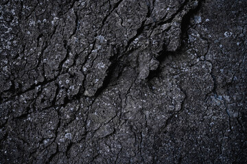 Dark stone texture background. Close up of limestone rock wall. Clay surface with cracks. Modern gray grunge background with space for design. Granite. Slab. Template. Backdrop. Wallpaper.