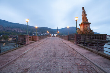 Auf der Alten Brücke in Heidelberg zum Sonnenaufgang. Lichter Leuchten am frühen Morgen im...