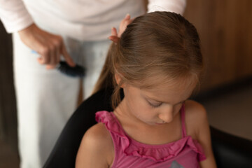 female hands are combing the girl's hair