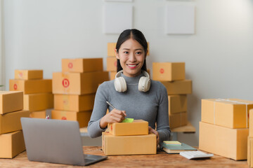 Confident Businesswoman: A young woman, with headphones around her neck, sits at a desk with a...