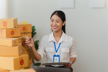 Successful Online Business: A smiling female entrepreneur stands proudly before a stack of shipping boxes, showcasing the tangible fruits of her hard work.