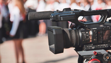 Professional video camera filming children during first school day celebration, creating memories...