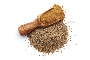 A wooden scoop filled with organic Carom seeds (Trachyspermum ammi) or Ajwain powder, placed beside a heap of carom seeds, isolated on a white background.