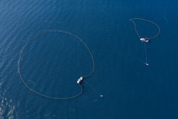 A bird's eye view of a large fishing vessel retrieving its nets. 