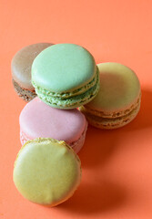 Macarons stacked, isolated, on orange background and copy space.	