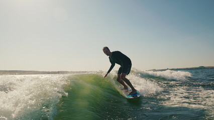 A wakeboarder performs exciting tricks on his board, moving quickly through the water. The footage...