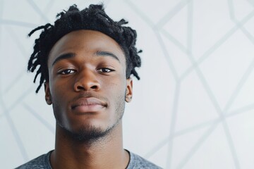 Confident young man with unique hairstyle poses against modern g