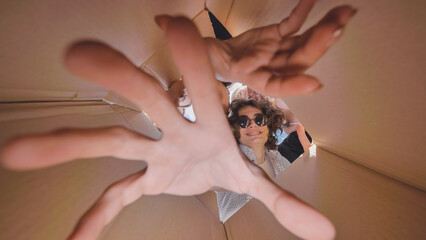 High school students having fun and exploring from inside a cardboard box during their summer break