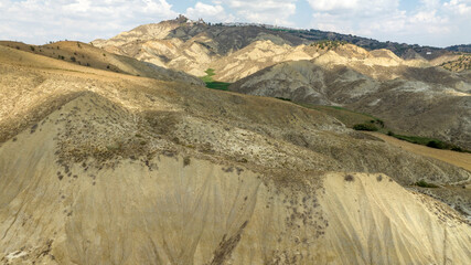 Aerial view of the Calanchi near Pisticci, in the province of Matera, Basilicata, Italy. Badlands are a type of dry terrain where sedimentary rocks and clay-rich soils have been eroded away.