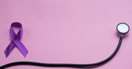 Purple epilepsy awareness ribbon with stethoscope and copy space on a pink background. World epilepsy day. Purple Day.