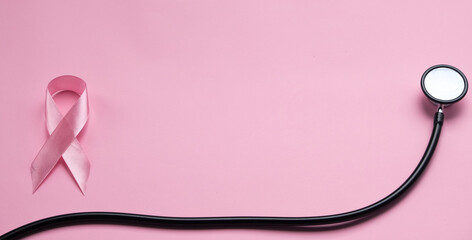 Obraz premium Stethoscope with pink ribbon on color background. Breast cancer ribbon
