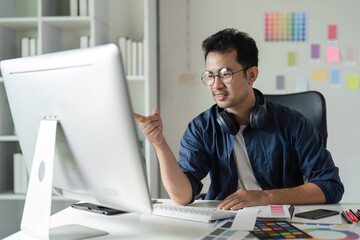 Fototapeta premium Creative Graphic Designer Working on Website Design in Modern Office with Digital Tools and Color Swatches