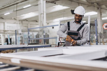 Factory worker assembling aluminum window frames in production line