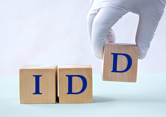 Cubes with the abbreviation IDD in the hand of a doctor.