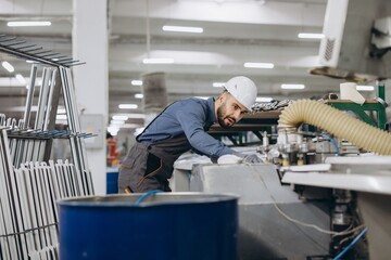 Factory worker operating machinery producing aluminum and PVC windows and doors