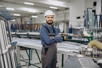 Technician posing with crossed arms in PVC windows and doors factory