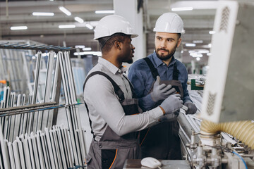 Factory workers discussing aluminum and pvc windows and doors production