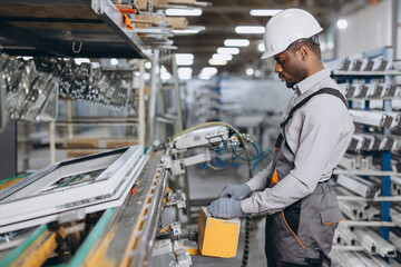 Fototapeta premium Factory worker operating machinery producing PVC windows and doors