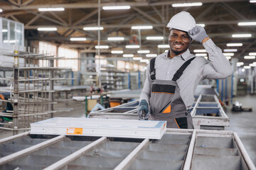 Factory worker assembling aluminum window frame in production line