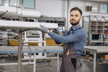 Factory worker picking aluminum profile for windows and doors production