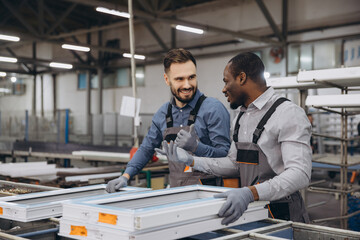 Factory workers assembling PVC windows in production line
