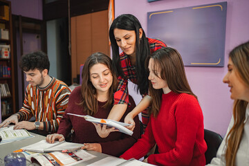 Female teacher explaining subject to her teenage students at language school