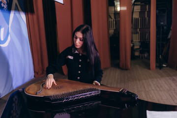 A woman on stage playing the bandura