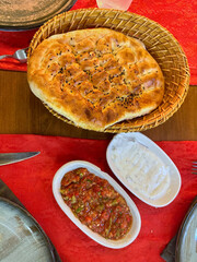 Traditional bread served with red and white sauces on a red tablecloth