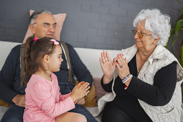 Joyful moments of grandparents and granddaughter at home