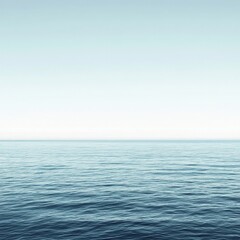 Obraz premium A calm blue ocean with no visible land. The sky is clear and the water is still. The scene is peaceful and serene