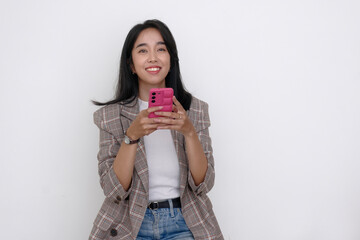 Happy facial expression of a young Asian woman reading messages from her smartphone