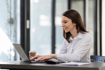 Professional Business Woman Working on a Desk with Laptop in Modern Office Environment