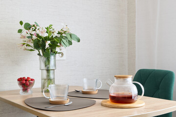 A Cozy and Inviting Dining Table Setup Featuring Tea and Fresh Flowers for Decoration