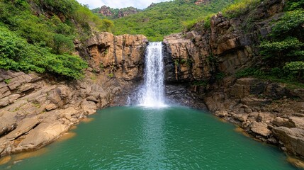 Naklejka premium Serene Waterfall Cascading into Crystal Clear Mountain Pool