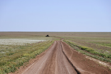 Obraz premium Dirt road through the steppe to a distant farm, Kalmykia Republic of Russia