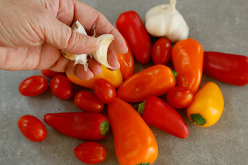 hand holding garlic with colorful mini pepper 
