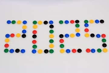 Vibrant candy pieces arranged to form the year '2025' on a white background, ideal for festive, creative, and celebratory designs