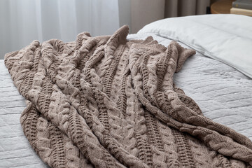 A Cozy Knit Blanket Perfectly Draped on a Bed Enhances Home Decor and Comfort Levels