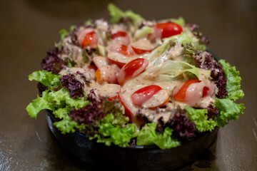Salad served in a bowl, on the table