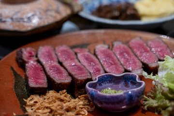 Medium rare sliced rib eye meat served on plate with vegetable